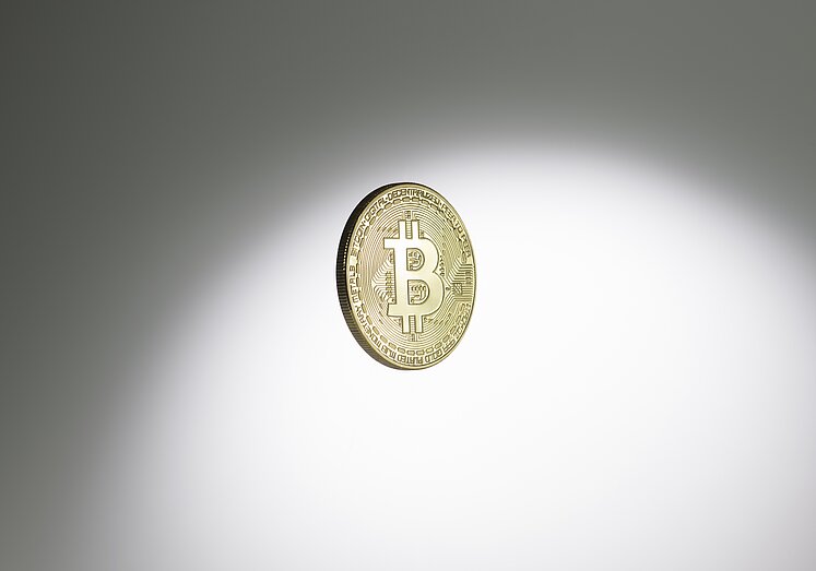 Physische goldene Münze, der die digitale Währung Bitcoin repräsentiert