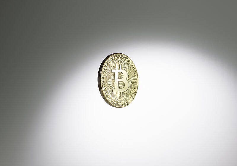Physische goldene Münze, der die digitale Währung Bitcoin repräsentiert