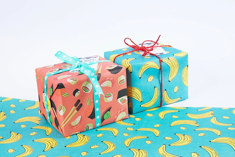 Zwei Geschenke in buntem Geschenkpapier mit Bananenmotiv