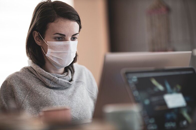 Frau mit Atemschutzmaske bei der Arbeit in einer Arztpraxis