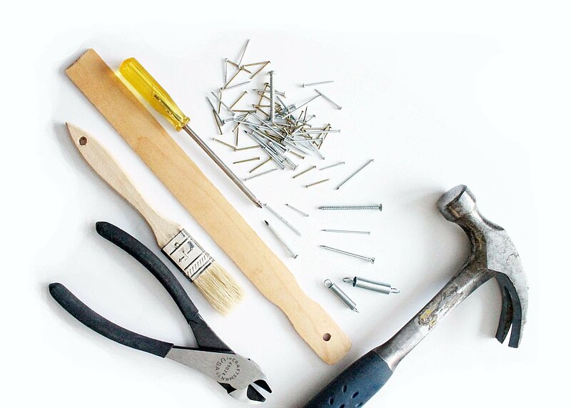 Reparatur__Renovierung_julie-molliver-Z3vFp7szCAY-unsplash Hammer, Schraubenzieher, Kneifzange und Nägel auf Werkbank