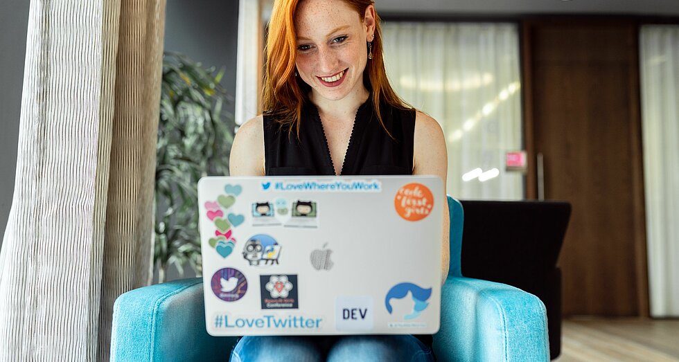 Lächelnde rothaarige Frau am Laptop