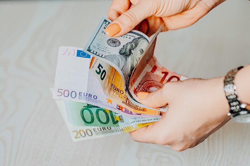 Lohnsteueromid-armin-unsplash. Hände mit Geldscheinen unterschiedlicher Größe