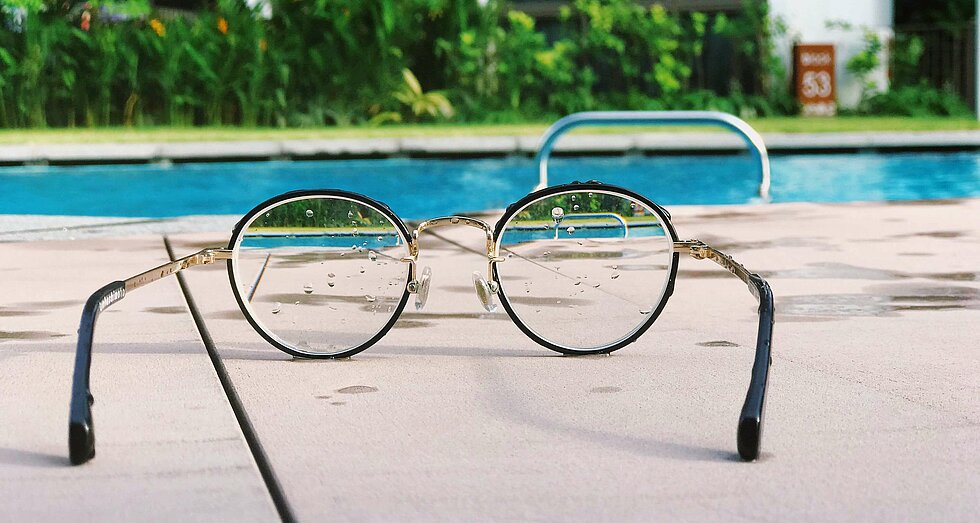 Brille liegt nahe eines Swimmingpools 