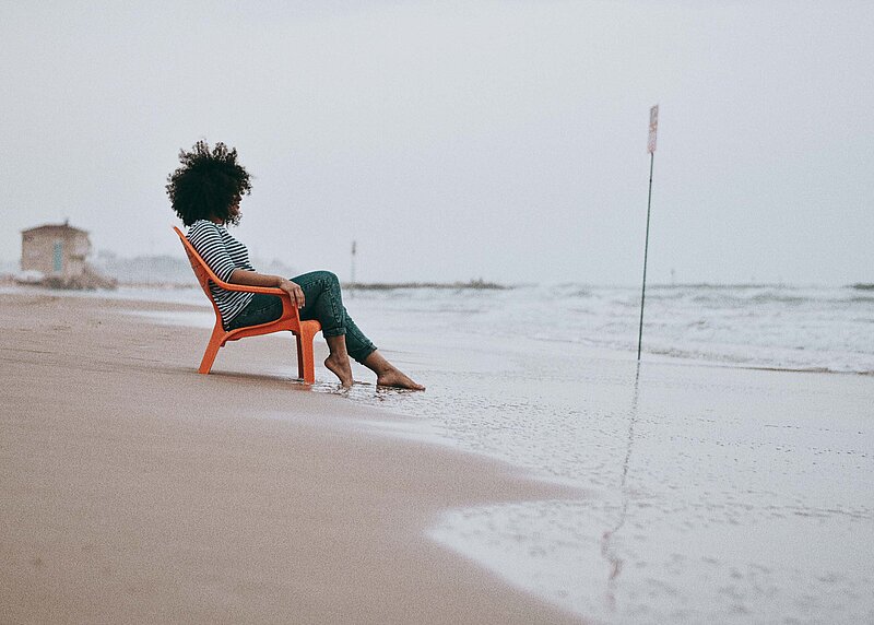 Einkommensteuer Grundlagen Frau in Liegestuhl an der Nordsee mit Blick aufs Meer