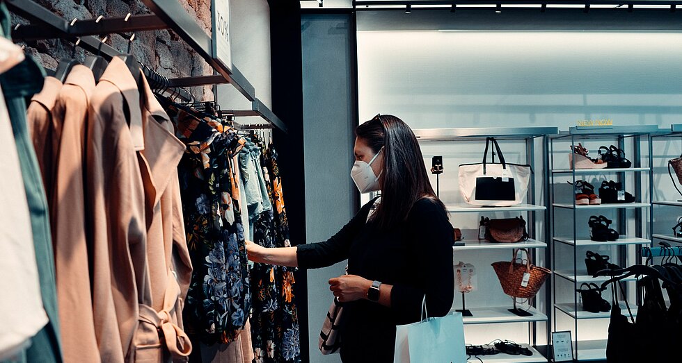 Frau mit FFP2-Maske in Modegeschäft