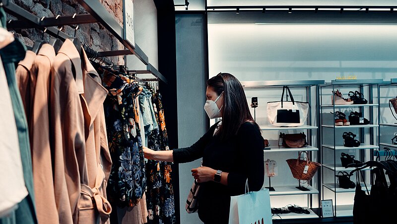 Frau mit FFP2-Maske in Modegeschäft