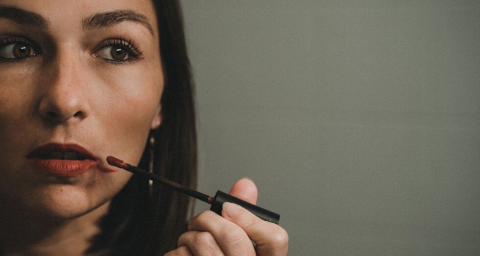 Frau trägt Lippenstift auf