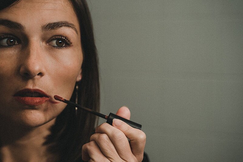 Frau trägt Lippenstift auf