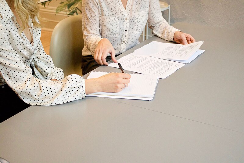Zwei Personen bei der Vertragsunterschrift