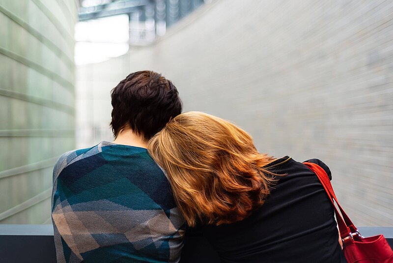 Außergewöhnliche Belastungen Junge Frau lehnt ihren Kopf auf die Schulter ihres Partners