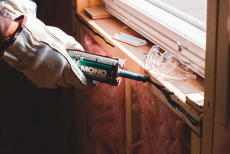 Farbe und Schutzkleidung an Holzverkleidung von Fenster