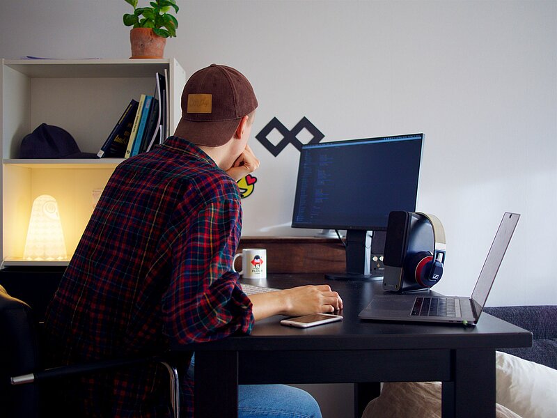 Junger Kleinunternehmer in seinem häuslichen Arbeitszimmer