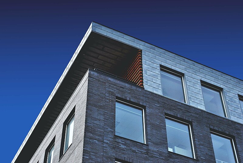 Grundsteuer Software oder Steuerberater Blick auf eine in den Himmel ragende Hausfassade