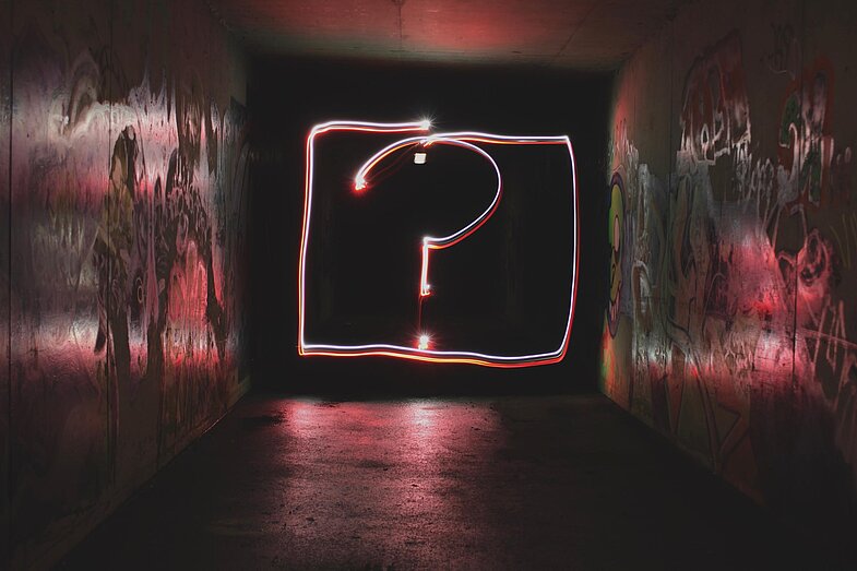 durch Licht gezeichnetes Fragezeichen in einer Box in einem Tunnel