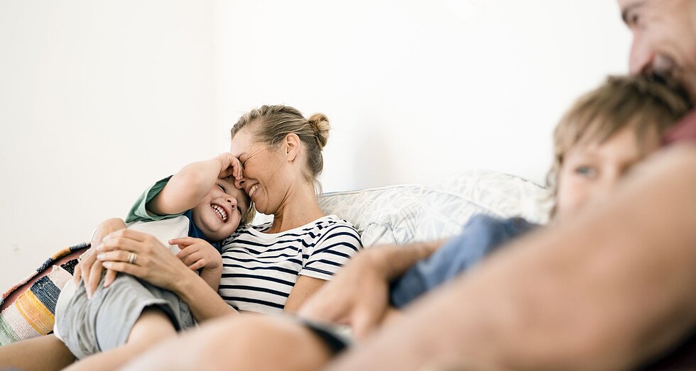 Familie kuschelt auf dem Sofa