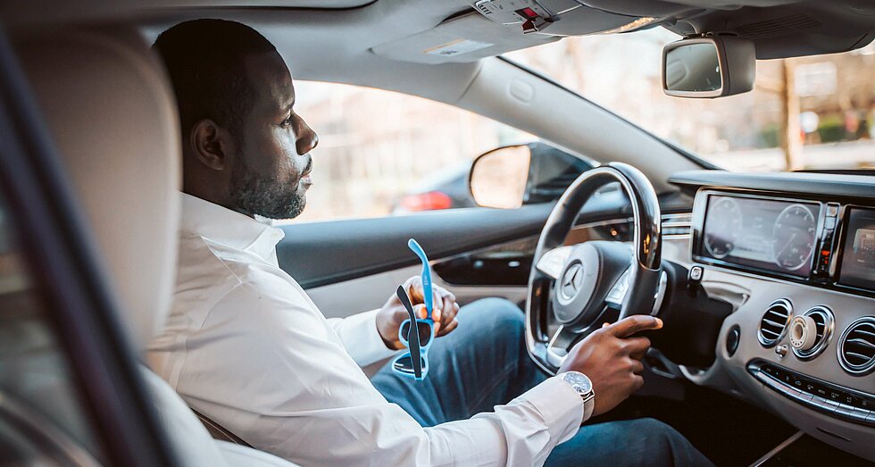 Junger Afroamerikaner am Steuer seines Autos