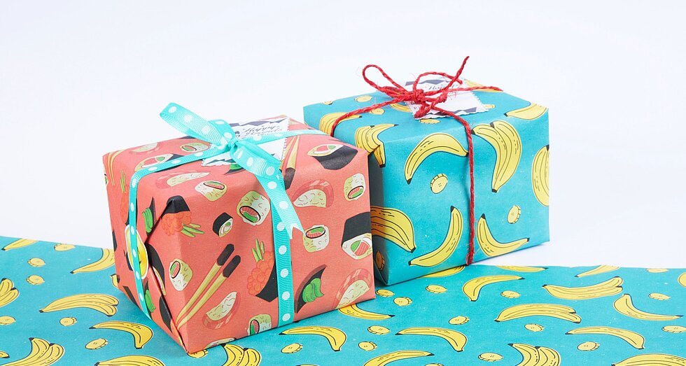 Zwei Geschenke in buntem Geschenkpapier mit Bananenmotiv