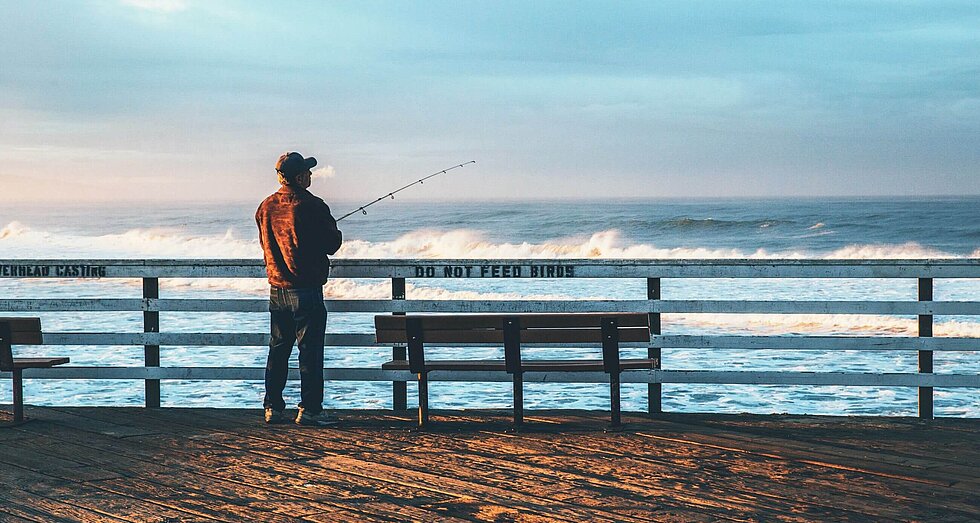Älterer Herr mit Blick auf das Meer