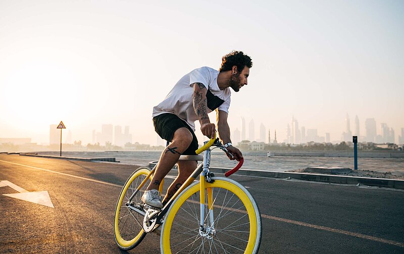 Jobrad Steuererklärung- Jonny Kennaugh-Unsplash Mann auf Rennrad fährt auf einer Straße.