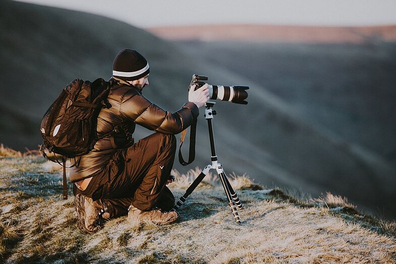 Fotograf mit Kamera auf einem Berg
