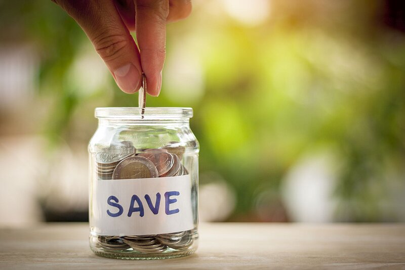 Glas voller Münzen mit der Aufschrift Save
