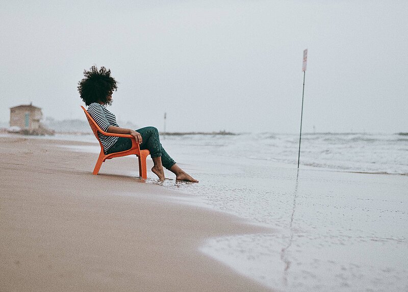 Einkommensteuer Grundlagen Frau in Liegestuhl an der Nordsee mit Blick aufs Meer
