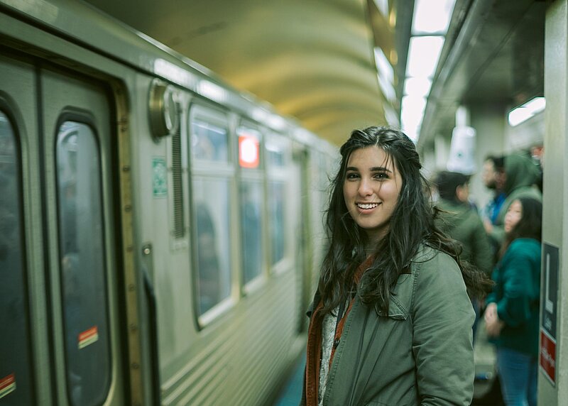 Pendlerpauschale-steven-aguilar-unsplash Frau im U-Bahn Tunnel steht neben U-Bahn und schaut in die Kamera