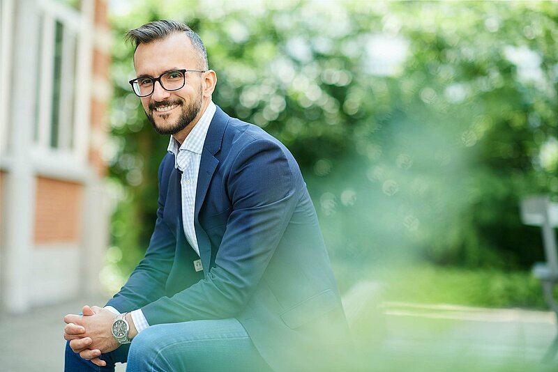 Steuerberater-fabio-rodrigues-unsplash Junger Mann in Anzug sitzt draußen