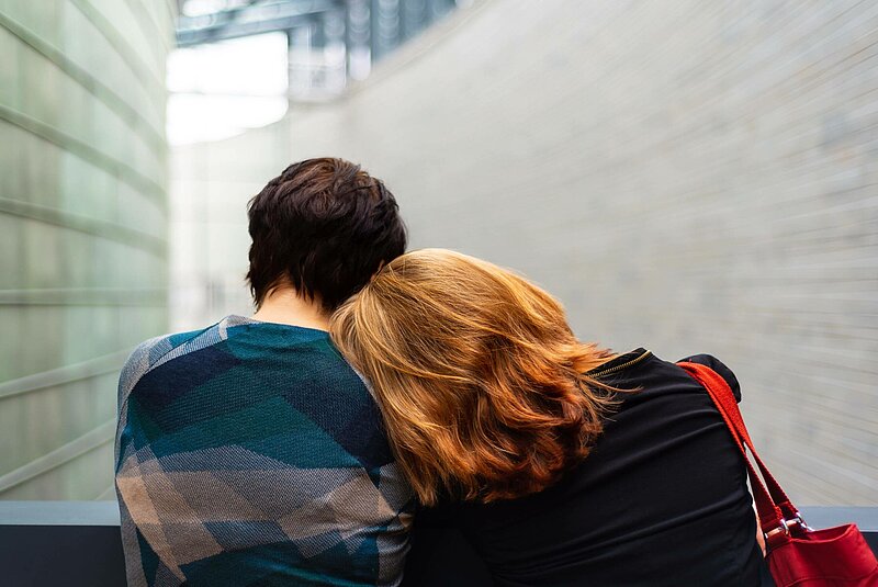 Außergewöhnliche Belastungen Junge Frau lehnt ihren Kopf auf die Schulter ihres Partners