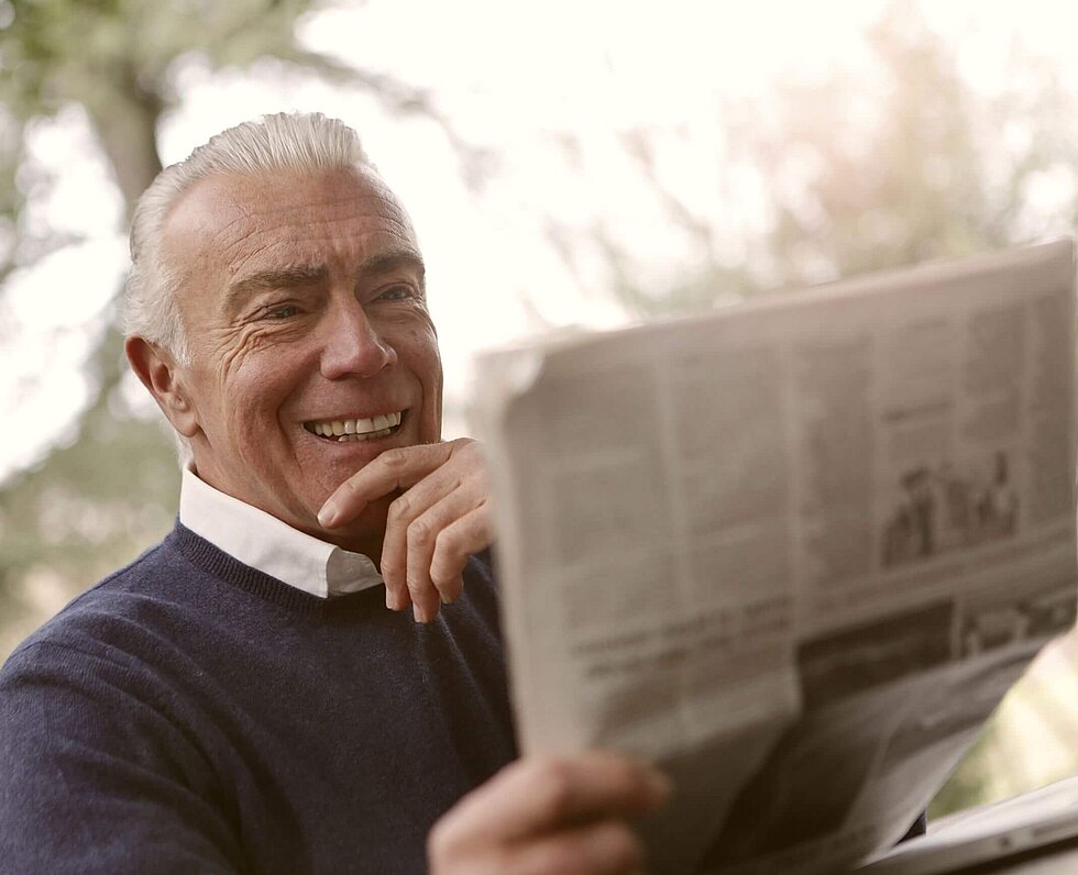 Rentner-Bruce Mars-Unsplash. Älterer Mann liest Zeitung